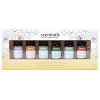 A box of Scentuals premium essential oils kit with six small bottles arranged in a line, each labeled with different scents like Sandalwood, Patchouli, Tea Tree, and Rosemary. 